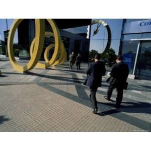  Businessmen Walking into Building with Spiral Art Outside 