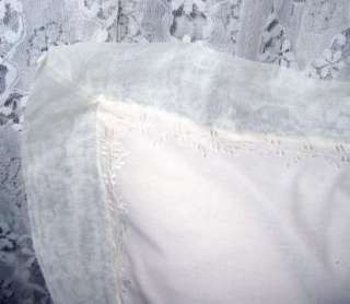   white floral embroidery decorates the edge of the sheer, organza trim