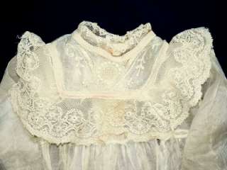   neck line is accented with lace and embroidery. The long sleeves are