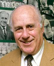 Boston Celtics president, Red Auerbach in front of collage, created by 